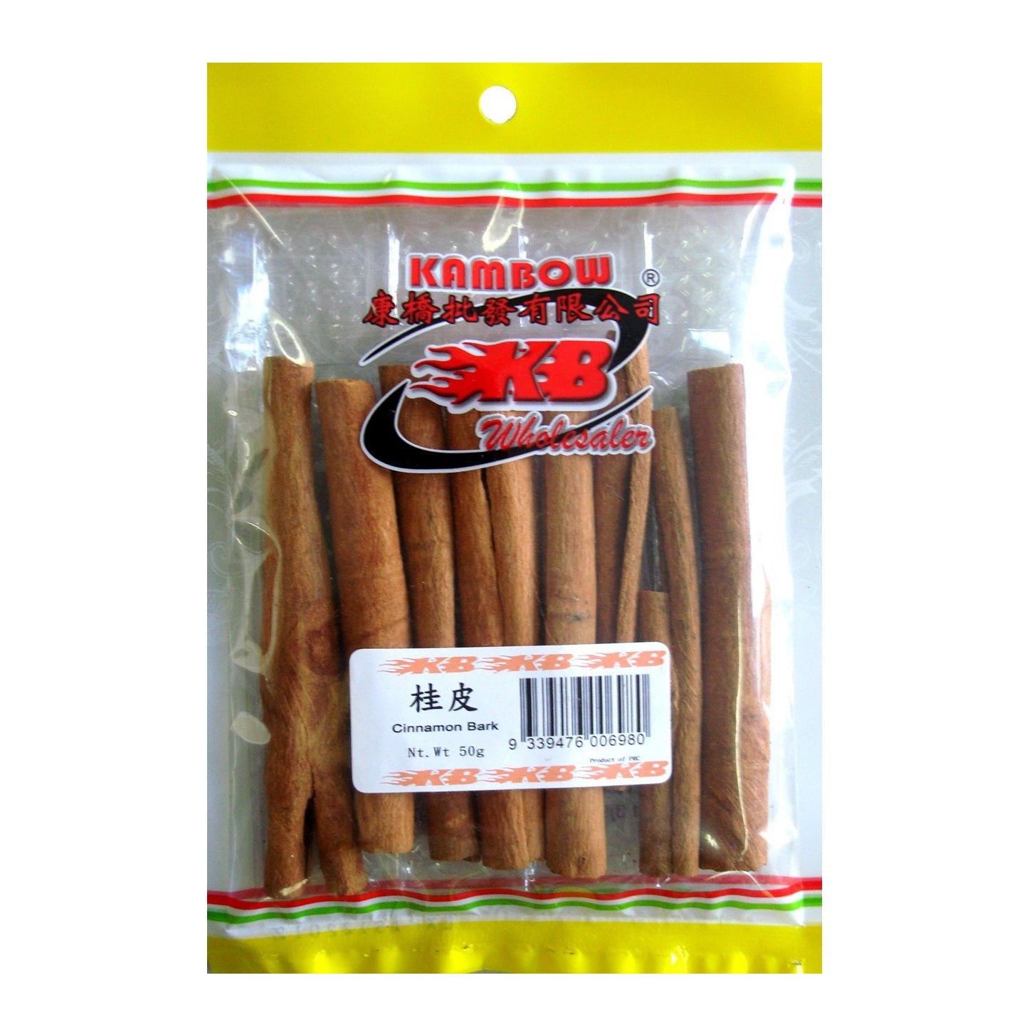 A clear plastic bag of Kambow brand cinnamon bark with a yellow top and bottom border, containing several brown cinnamon sticks, on a white background.