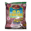 A bag of Southern Black Sesame Cereal (南方黑芝麻糊) on a plain white background. The packaging features a blue central label with yellow Chinese text, surrounded by a purple and black patterned design with a green top border.