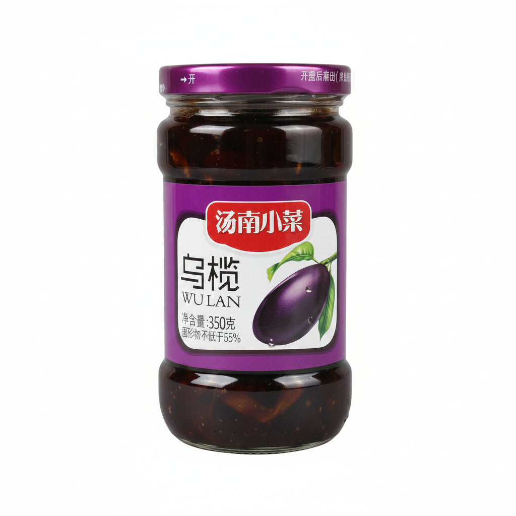 A glass jar of Wulan black olives in soy sauce by the brand 汤南小菜, featuring a purple lid and a purple label with a graphic of a black olive, set against a neutral gray background.